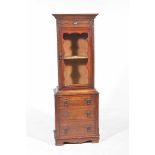 A 19th Century and later oak glazed cabinet With a single glazed door above three drawers,