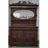 A late Victorian walnut mirror back sideboard With a shaped pediment above an oval bevelled plate