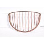 A large vintage cast iron hayrack Of semi circular form, each with arched tubular rack,