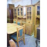 A modern pine dining room suite Comprising a breakfront glazed dresser having four glazed doors