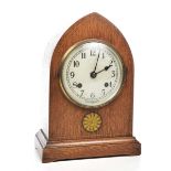 An early 20th Century oak cased mantle clock Of arched form,