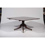 An early 19th Century mahogany centre table The rectangular tilt top with rounded corners supported