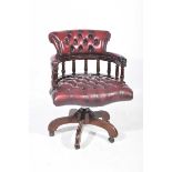 A reproduction oxblood red leather revolving Captain's chair With a padded back rail supported on