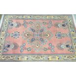 An Bokhara style Persian rug The pastel pink covered ground with central Persian foliate motif,