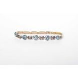 A blue zircon bracelet With alternating pierced white metal links, to precious yellow straps,