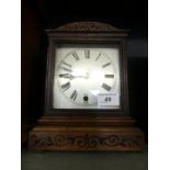 A late 19th/early 20th Century oak cased mantel clock with carved detail,