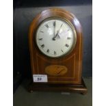 An Edwardian mantel clock, in oak and inlaid case, 22cm high.