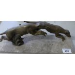 A continental spelter model of two greyhounds on marble plinth bases,