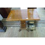 An Art Deco oak side table, raised on stepped plinth supports.
