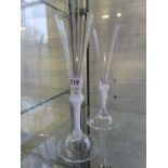 A pair of contemporary clear glass champagne flutes with air twist stems.