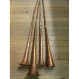A collection of copper post horns, various sizes, together with iron weight.