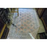 A vintage eastern rug having stylised decoration on beige ground.