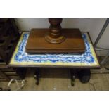 A vintage metal framed coffee table having blue and white tile inset top.