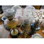 A collection of three late 19th/early 20th oil lamps, one with pierced cast metal base,