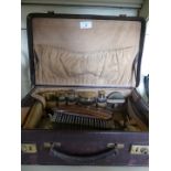 A vintage leather vanity case fitted with various jars,