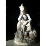 A Lladro model of a girl with a doll