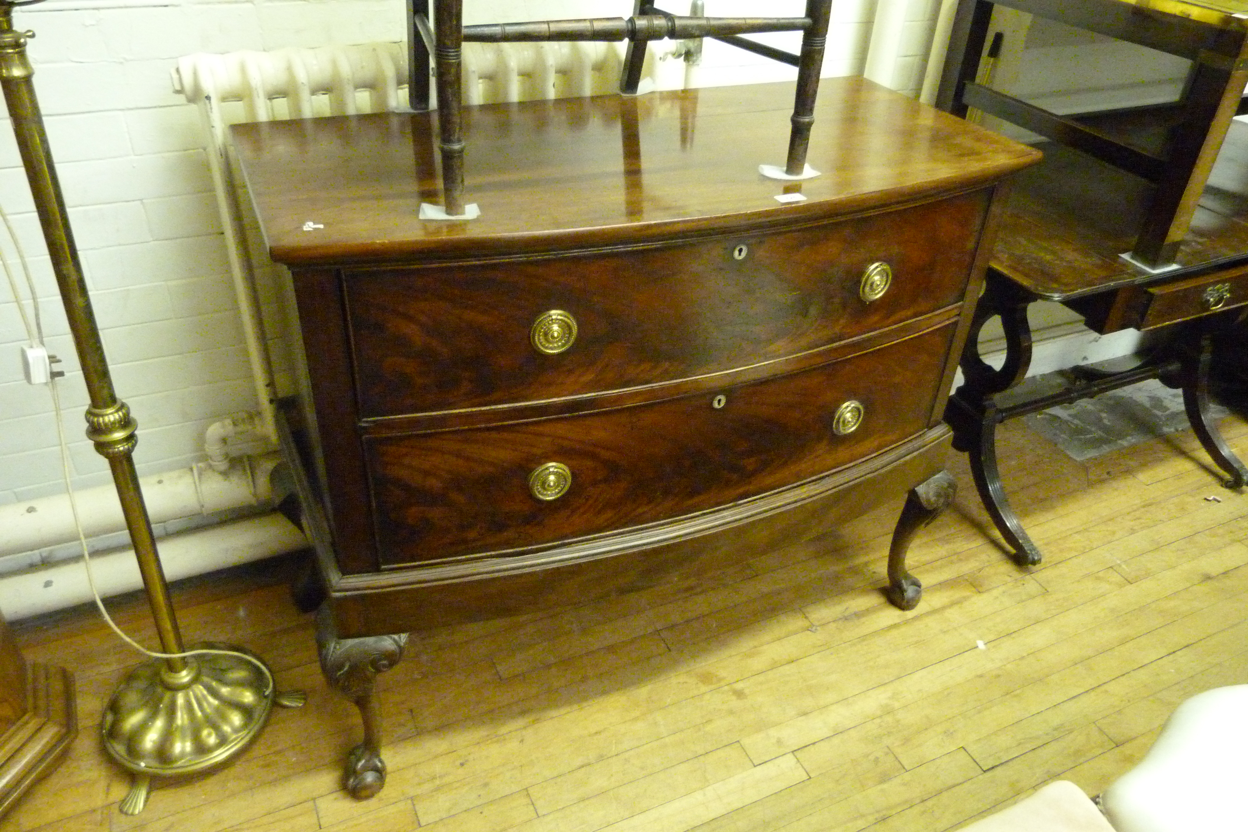 A Georgian mahogany bowfront chest of drawers The two long drawers with circular brass drop handles,