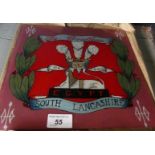 A square glass panel decorated with the crest of South Lancashire Regiment.