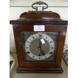 A reproduction mahogany Georgian style bracket clock, complete with key and pendulum.