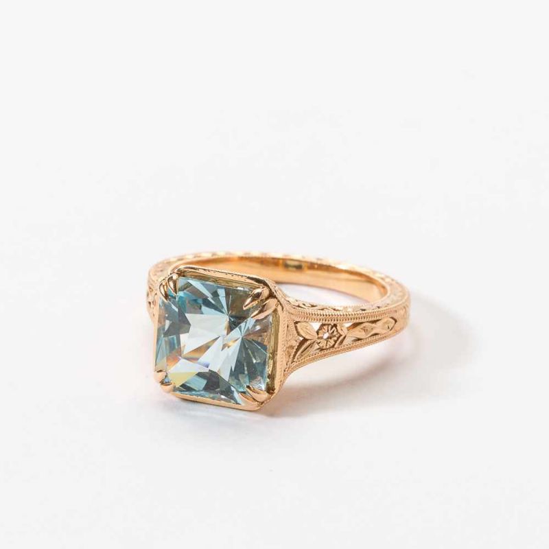 An 20 carat gold and aquamarine ring 21st century Centered by a square facetted aquamarine, to an