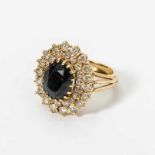 An 18 carat, gold, diamond and sapphire cluster ring Circa 1970 Centered by an oval-cut blue