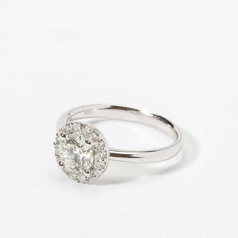 An 18 carat white gold and diamond cluster ring 21st century Centered by a circular-cut diamond