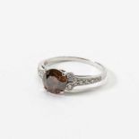A 14 carat white gold, brown diamond and diamond single stone ring Late 20th century Centered by a