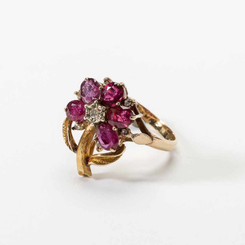 A ruby and diamond ring England, circa 1970 Designed as a flower, the leaves ruby-set and with