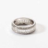 An 18 carat white gold and diamond eternity ring Late 20th century Centered by a band of step-cut