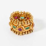 An 18 carat gold, ruby and emerald ring Circa 1990 The flexible ring set at intervals with rubies