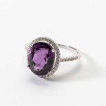An 18 carat white gold, diamond and amethyst cluster ring 21st century Centered by an oval-cut