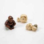 A collection of three Japanese netsuke19th centuryOne ivory netsuke carved as a child with a fruit