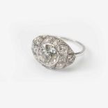 A platinum and diamond ring20th centuryCentered by collet set old-cut diamond, within openworked