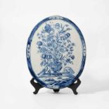 A Dutch Delft blue and white oval plaque18th centuryDecorated with a flower vase filled with an