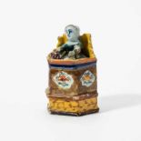 A Dutch Delft polychrome figure of a child in a high chair18th centuryThe six-sided high-backed