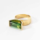 An 18 carat gold and tourmaline ringCirca 1980Centered by a rectengular-facetted green tourmaline in