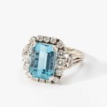 An aquamarine and diamond cluster ringCirca 1950Centered by a step-cut aquamarine within circular-