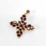 A 14 carat gold and garnet pendantCirca 1890Cross-shaped and throughout set with facetted garnets.