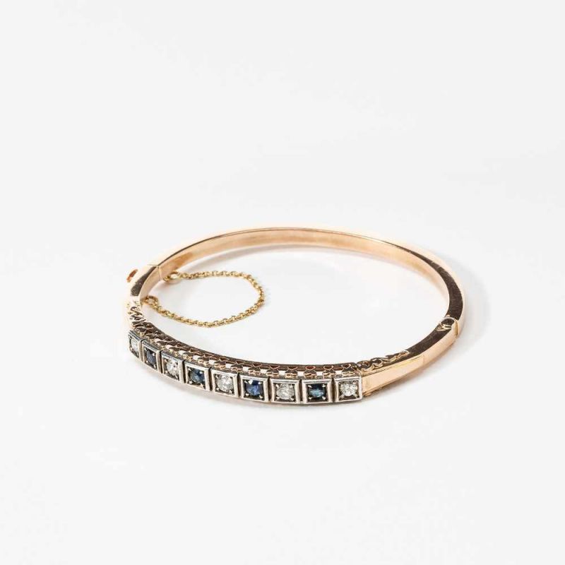 A 14 carat yellow and white gold diamond and sapphire bangle bracelet20th centuryAlternately set