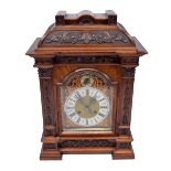 A large late Victorian carved bracket clock with arched case,