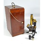 A cased unnamed brass and lacquered monocular microscope with angled lens inscribed 'Carl Zeiss