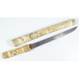 A Japanese Meiji period bone wakizashi, with carved decoration throughout, length of blade 29cm.