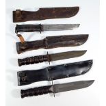 Two American issue knives, with ribbed handles and complete with scabbards, length approx 31cm,