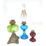 A late Victorian metal based oil lamp decorated with anchors and with green glass reservoir,
