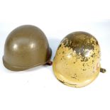 Two WWII/mid-20th century helmets comprising a US M1 pattern beige painted example with canvas