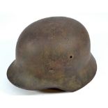 A German WWI helmet with internal leather lining and chin strap, height 16cm.