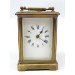 A circa 1900 French brass carriage clack with swing loop handle above white enamel dial set with