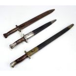 Three various bayonets in scabbards with various markings (3).