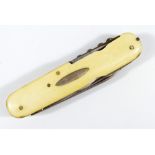 An ivory faced multi-tool comprising scissors, two knives, a screwdriver with small serrated edge,