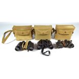 Three pairs of military issue canvas cased binoculars;